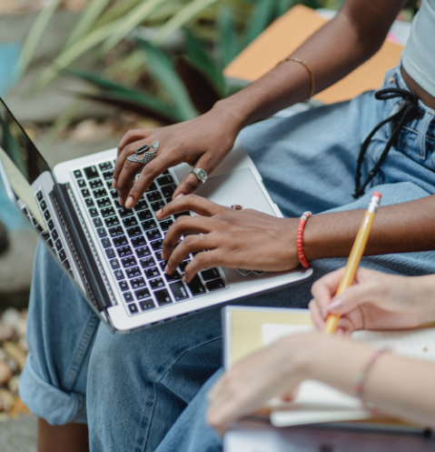 girl typing on her computer outside