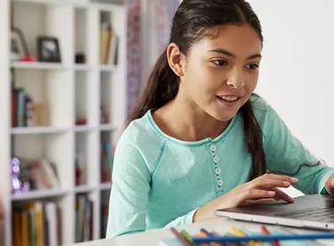 girl-sitting-down-using-laptop-at-home