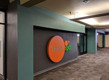 A hallway depicts a sign that reads "Think Spot"