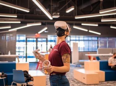 Photo of a woman using a VR headset at the Next Lab