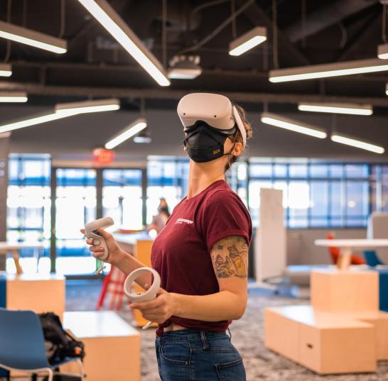 Photo of a woman using a VR headset at the Next Lab