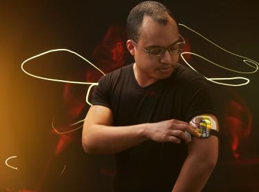 A man looking at a healthcare device on his arm